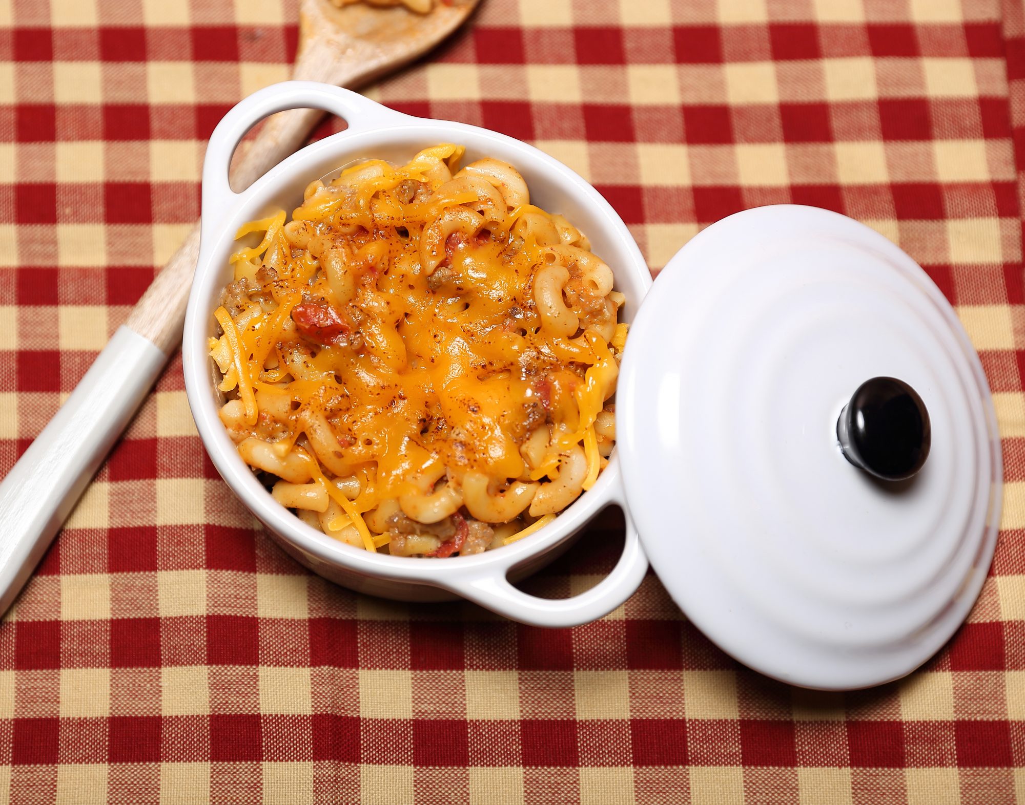 sausage macaroni and cheese on a red and tan checkered tablecloth